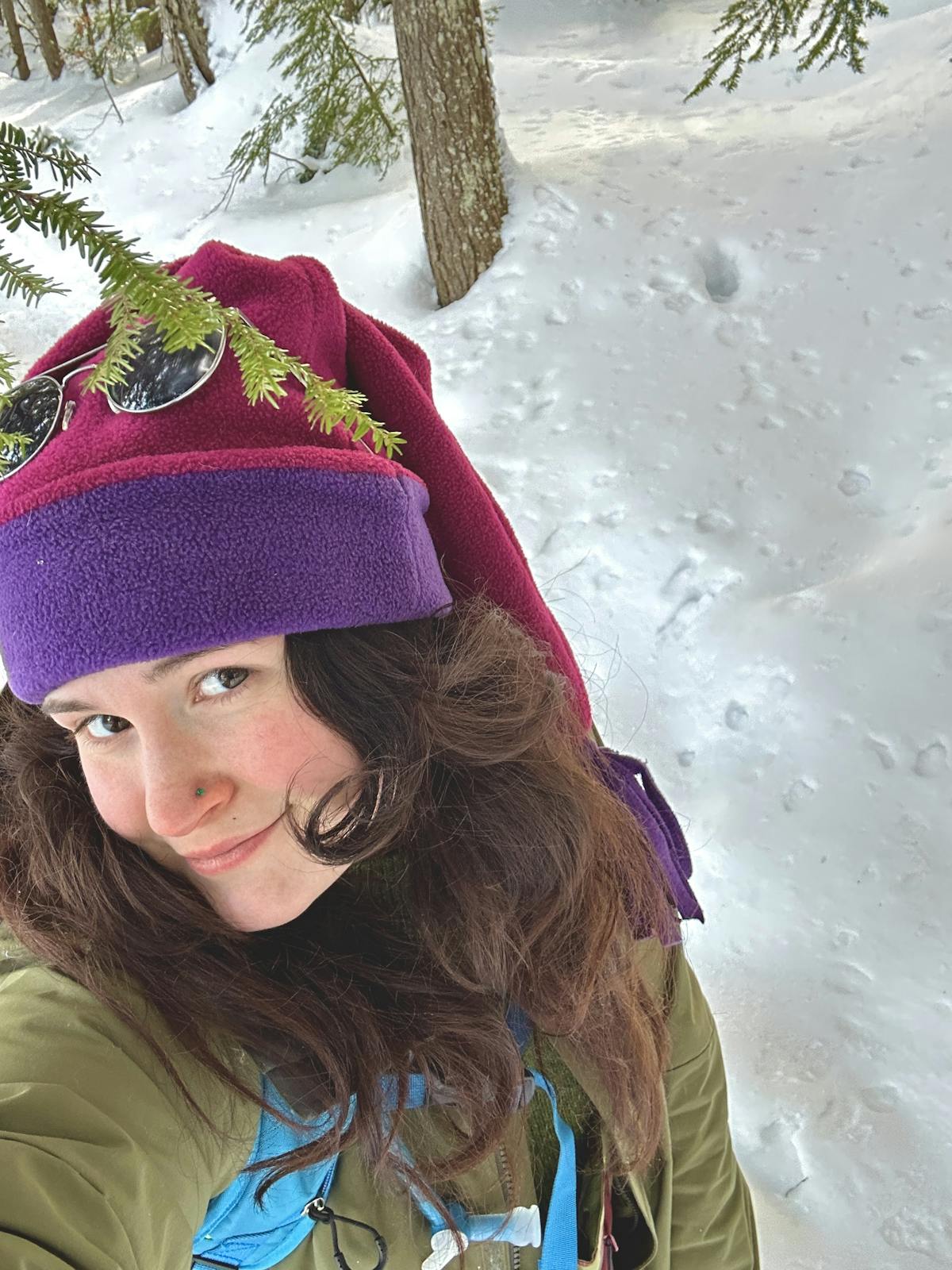 a woman wearing a hat with snow on the ground