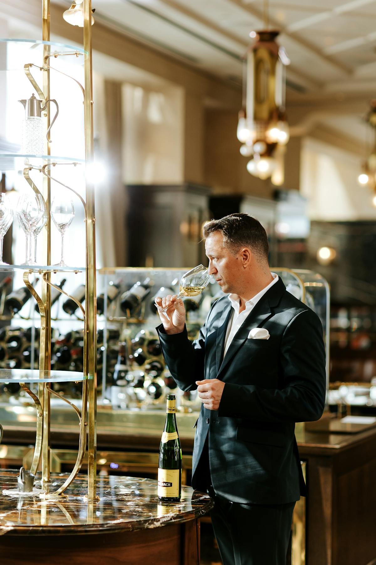 a man standing next to a glass of wine