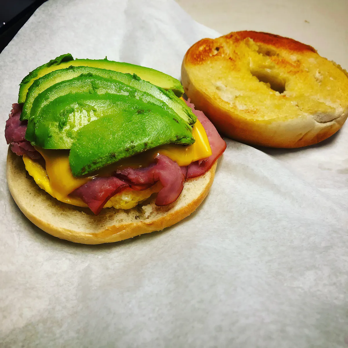 Hollywood Canteen: buttered and toasted breakfast bagel, scrambled egg, American cheese with ham and avocado