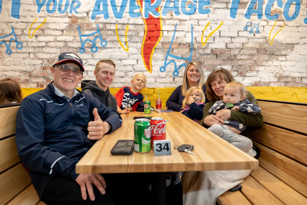 a group of people sitting around a wooden table