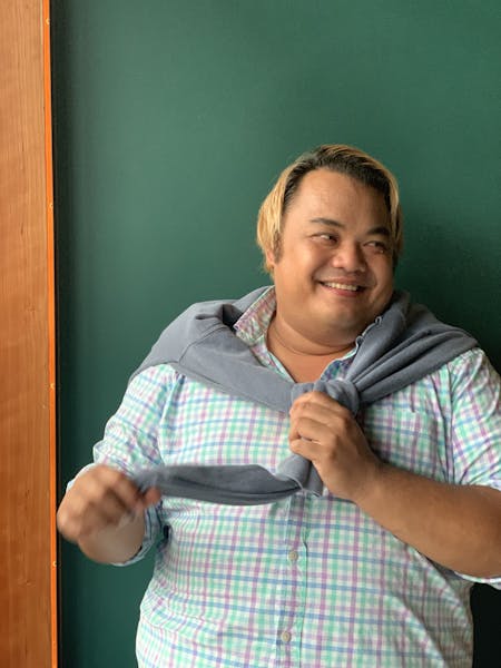 a man in a striped shirt and smiling at the camera