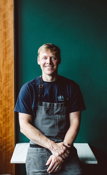 a man in a blue shirt sitting on a table