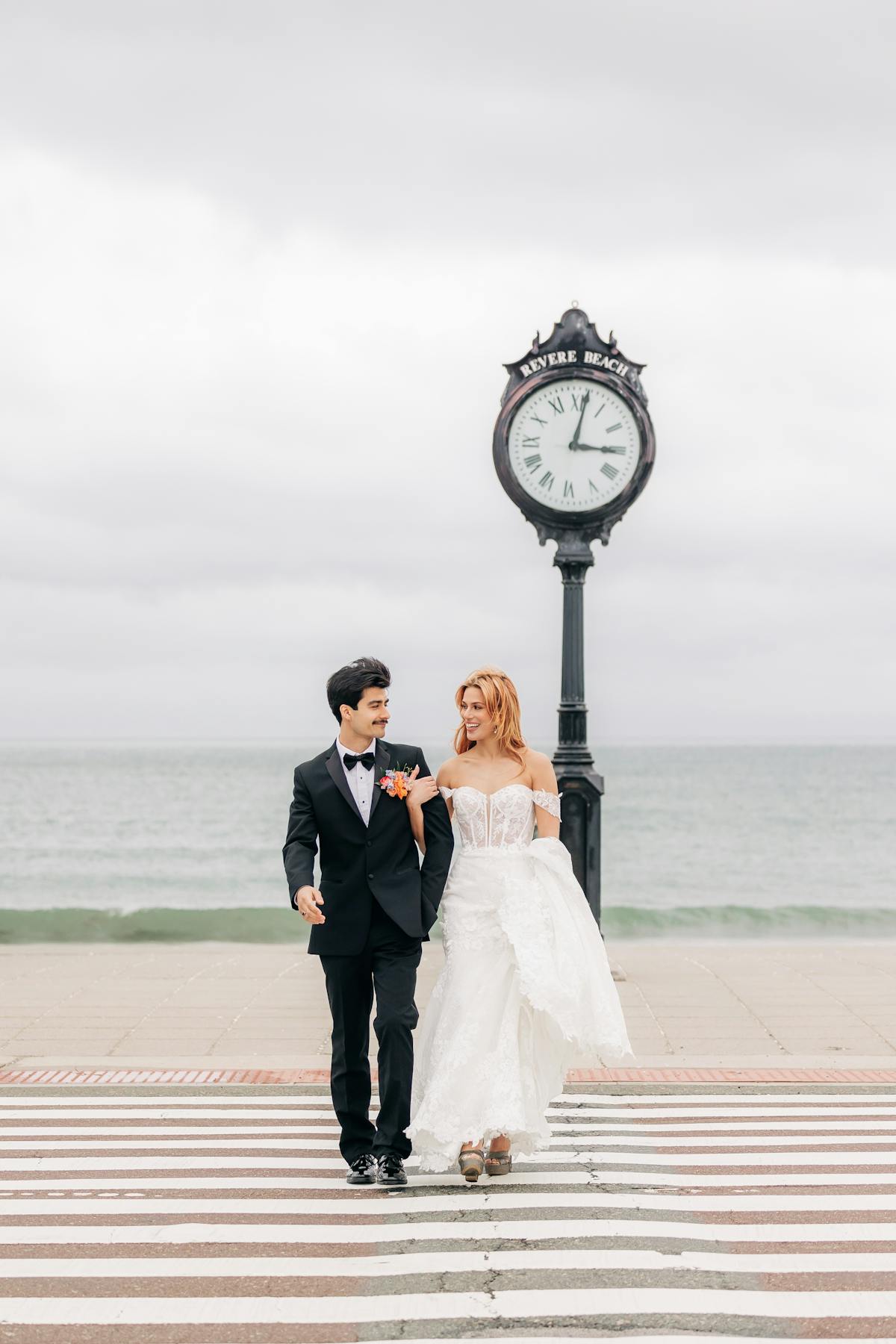 a groom and bride standing next to a clock