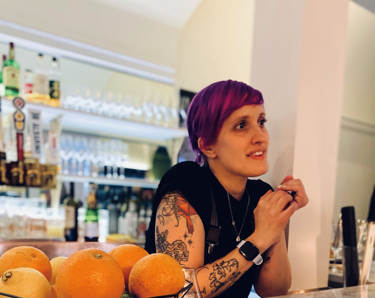 a person standing in front of oranges