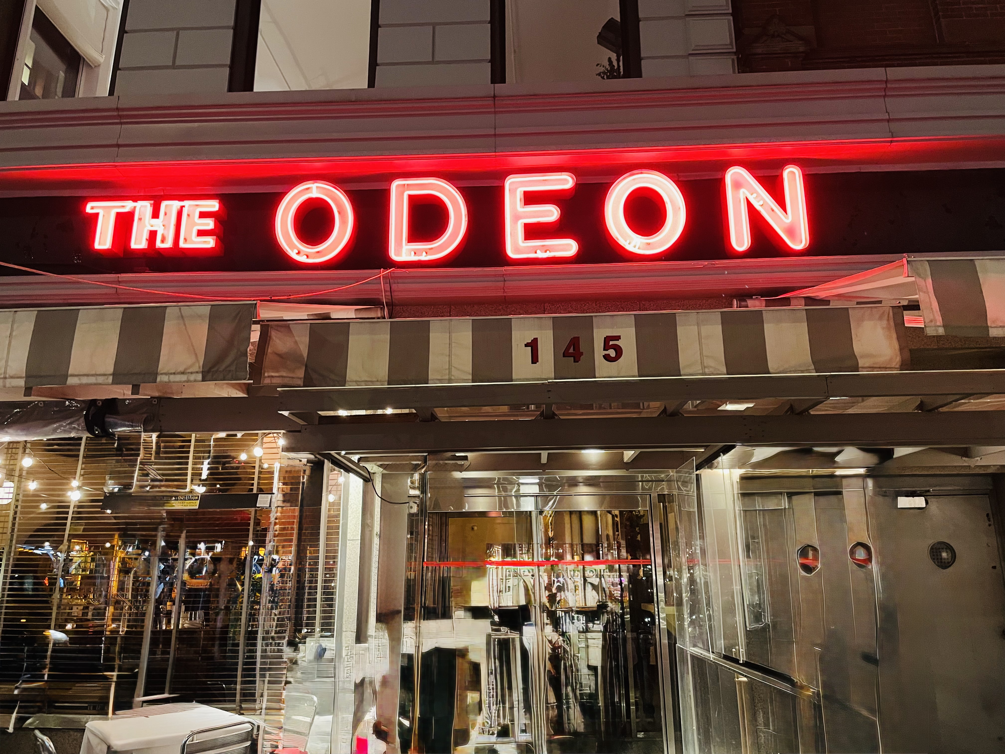 The entrance at night with the glow of the red neon sign