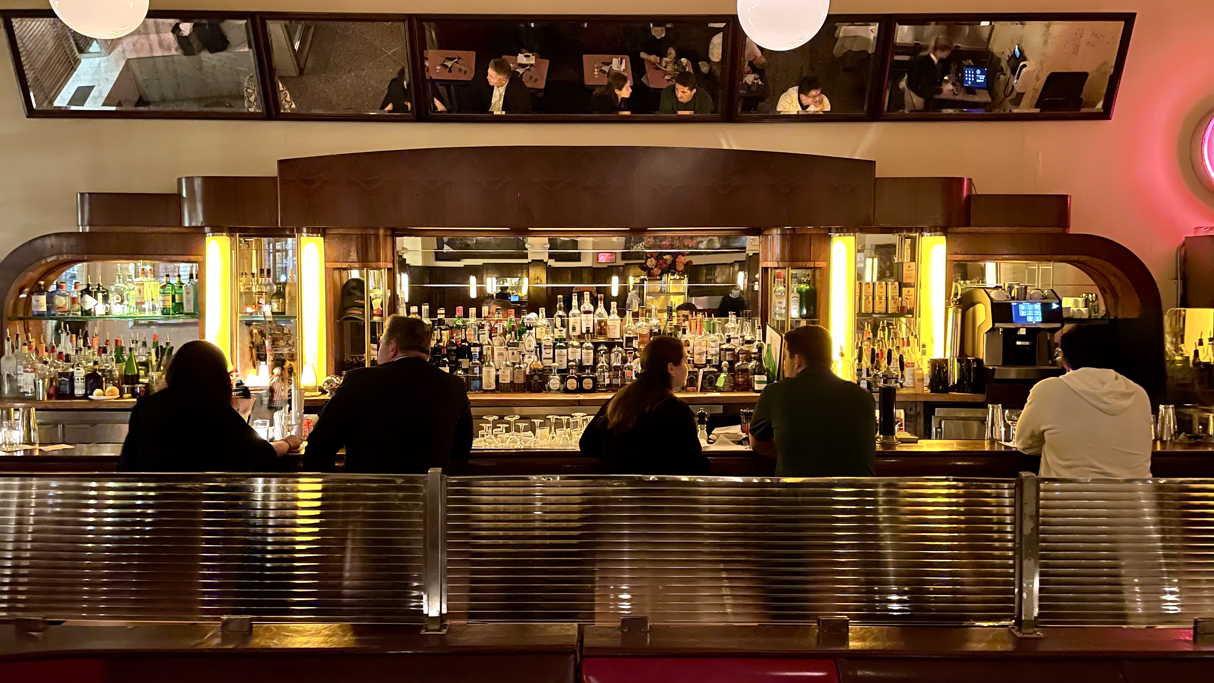 Guests mingling at the dimly lit bar over classic cocktails