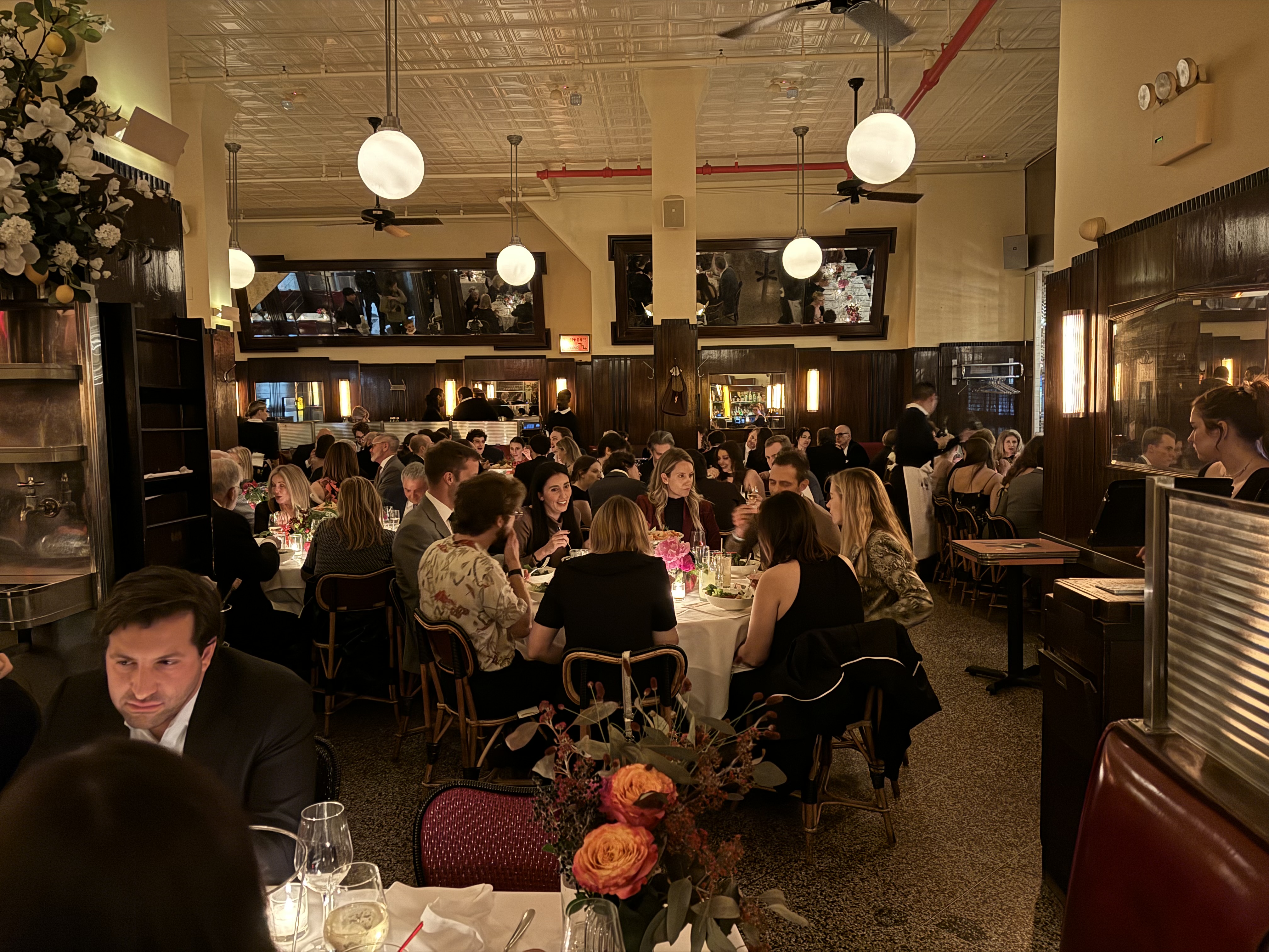 groups of guests neighbors globe lights vintage mirrors terrazzo floors dark wood detail festive special