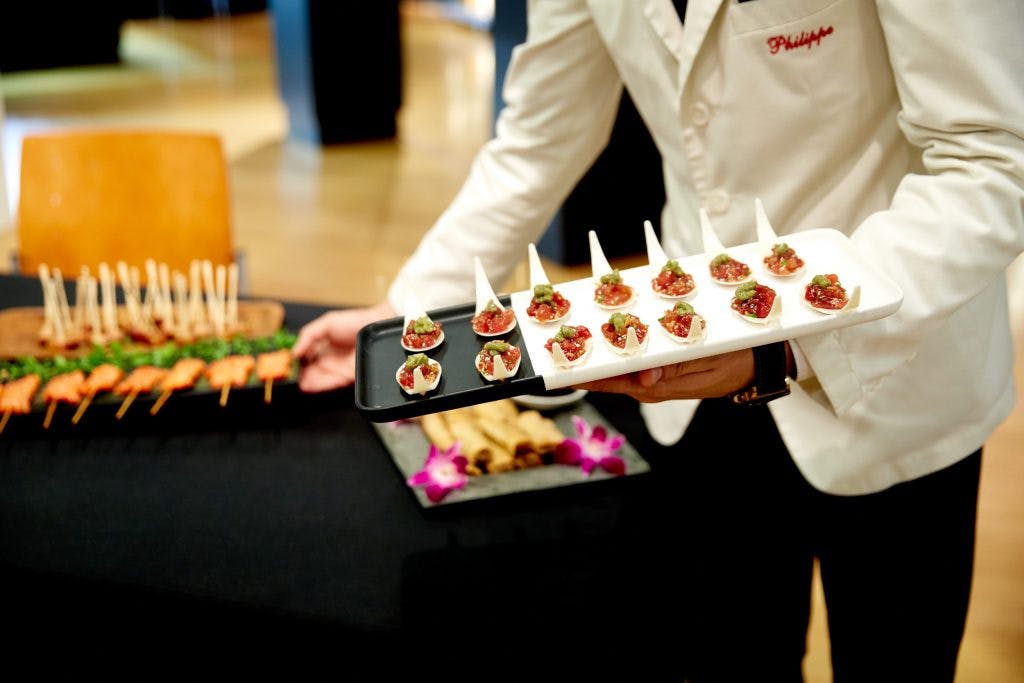 a person holding trays of food