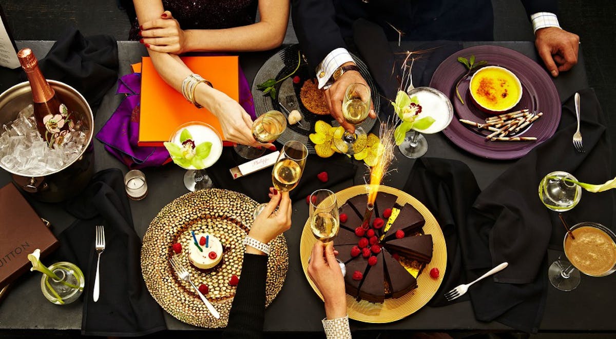 a group of people sitting at a table with plates of food