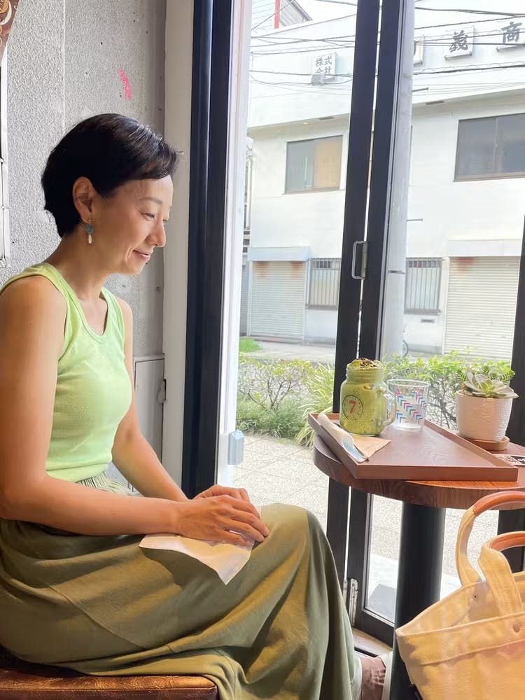 a woman sitting next to a window