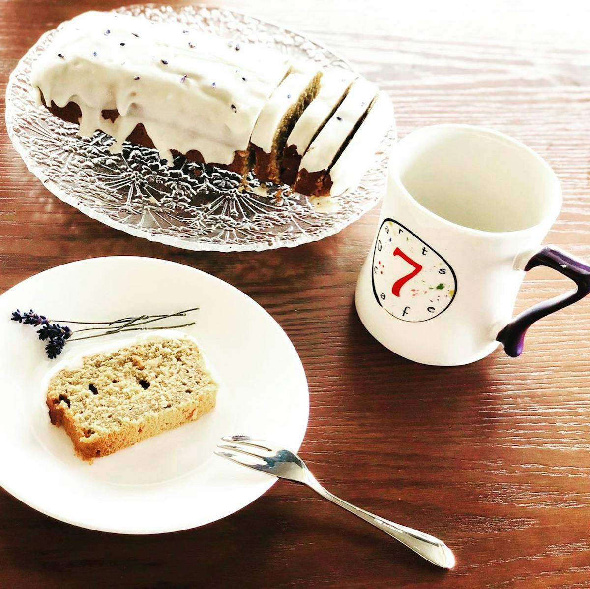 a piece of cake on a plate next to a cup of coffee