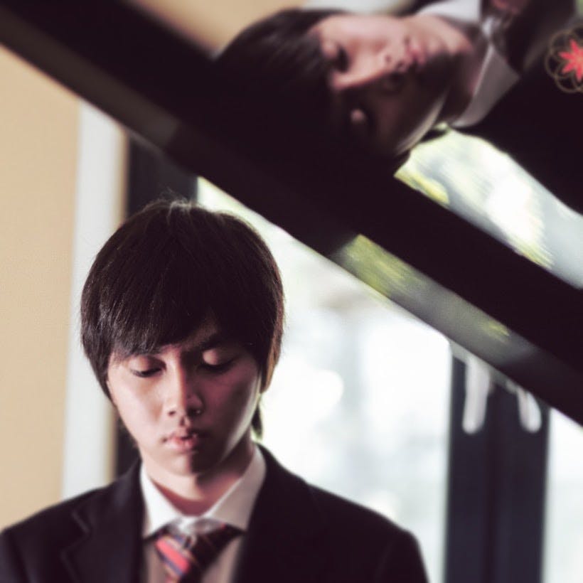 a man in a suit standing in front of a window