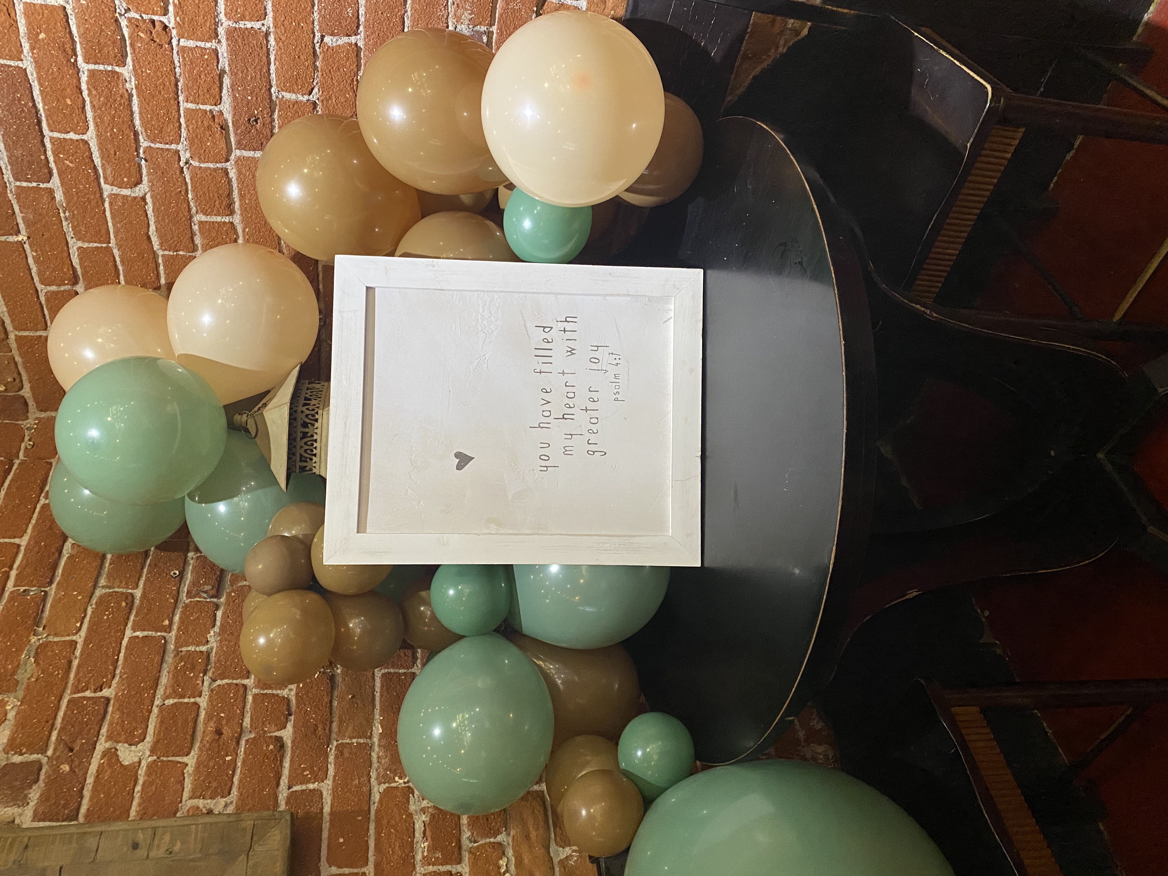 a table that has a sign on a brick wall
