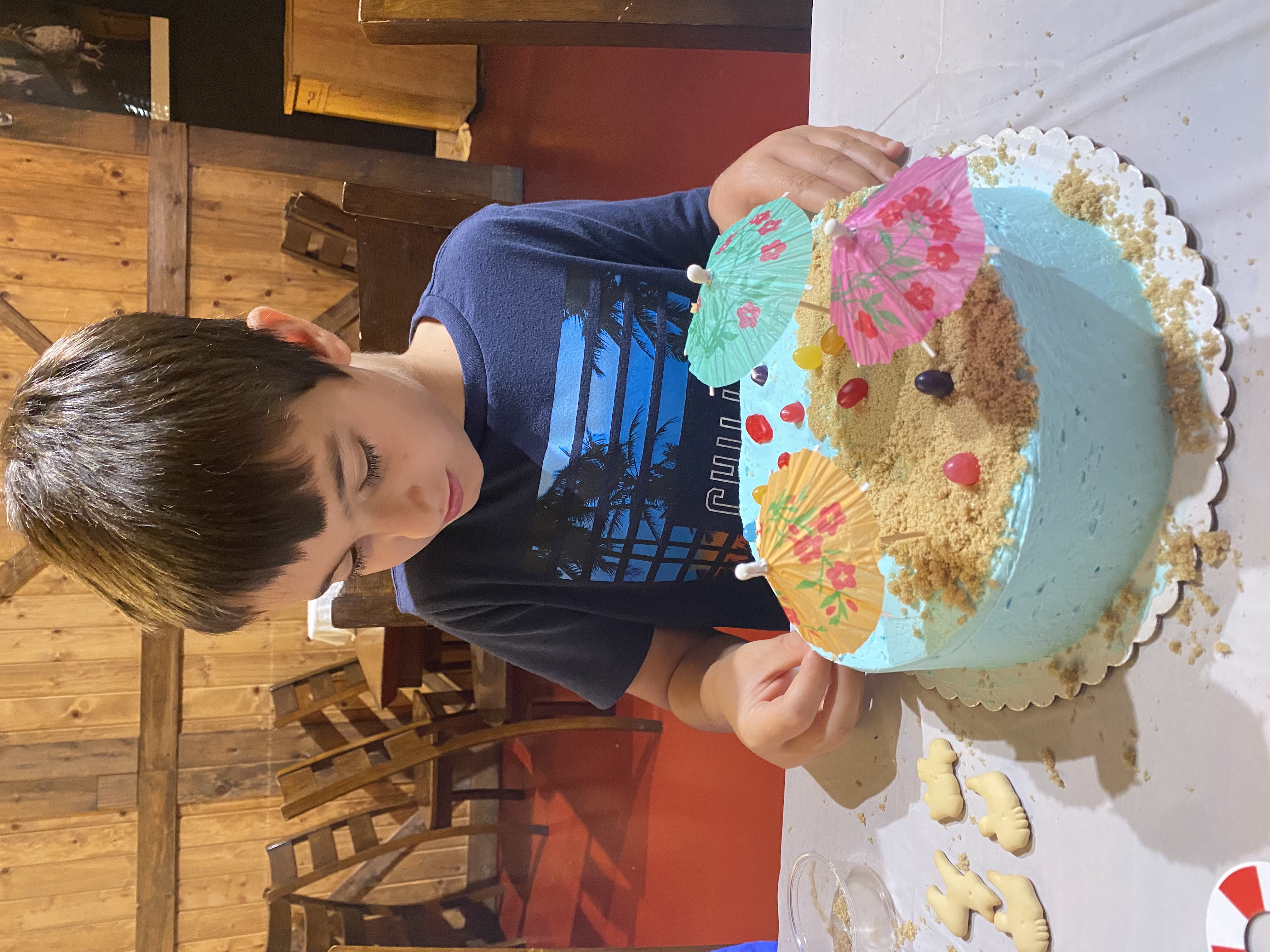 a little girl sitting at a table with a birthday cake