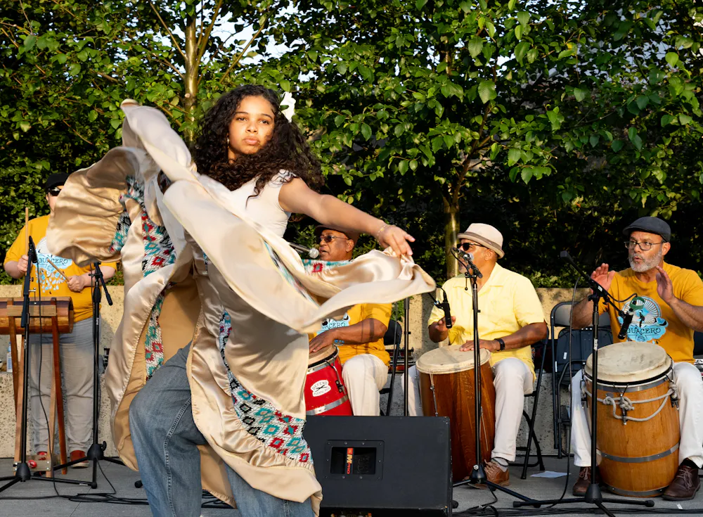 a woman dancing with a group of people playing instruments