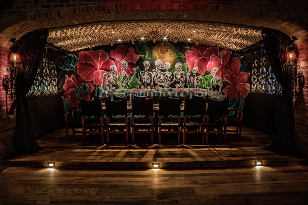 a group of people in a room filled with furniture and vase of flowers