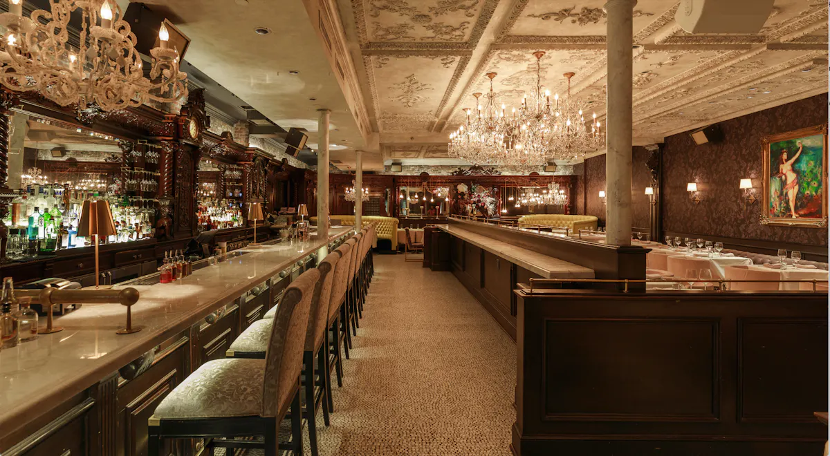 a bar with chairs and chandeliers