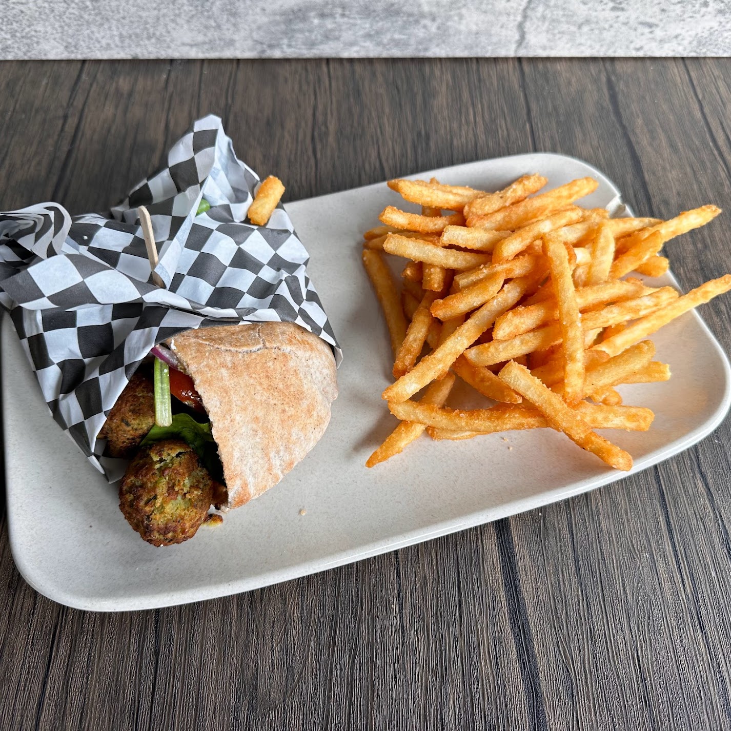 a plate of food with a sandwich and fries on a table
