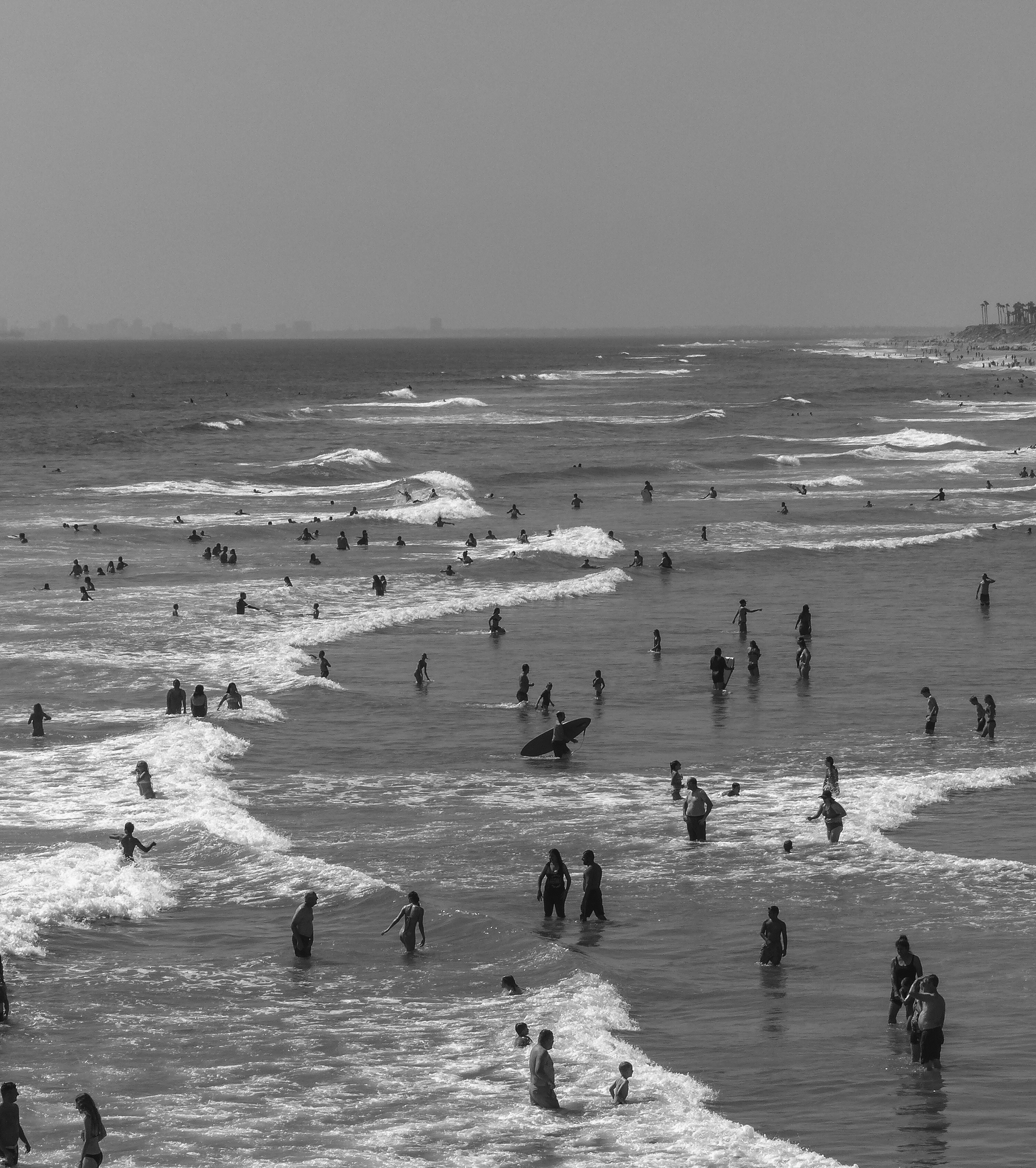 a group of people walking across a beach next to the ocean