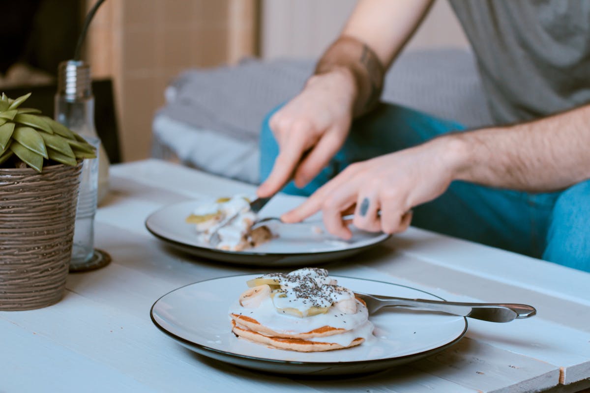 a person cutting food on a plate