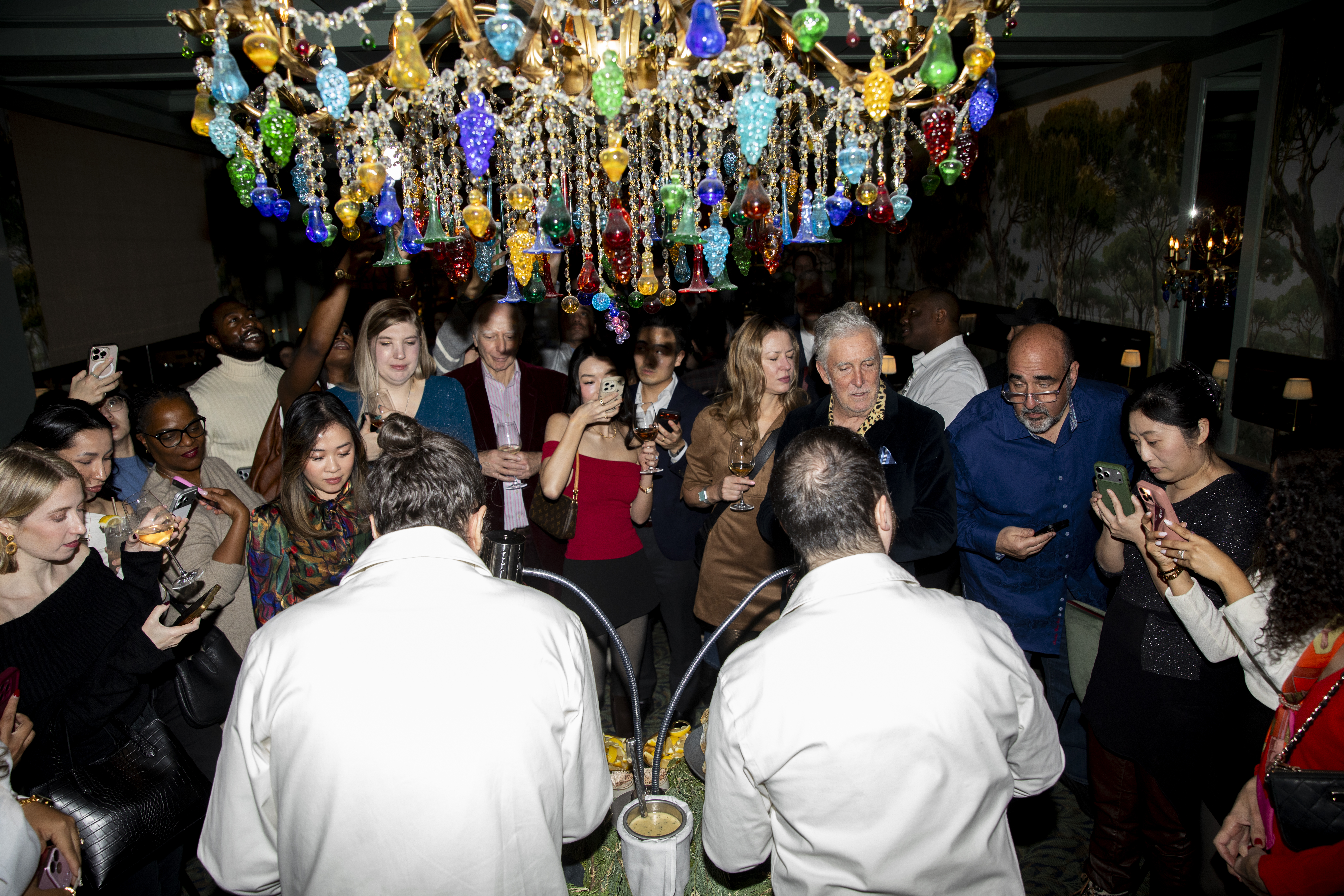 a group of people standing around a chandelier