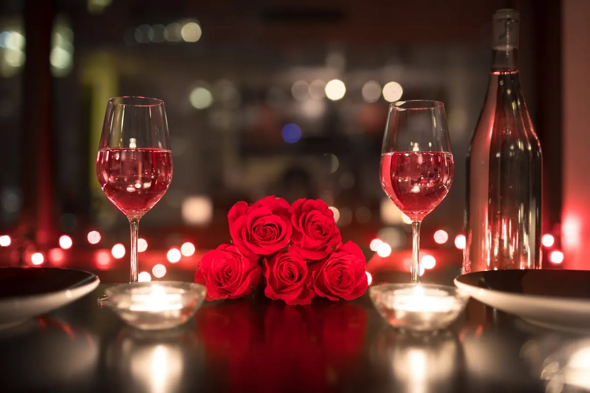 a bottle of wine glasses sitting on a table