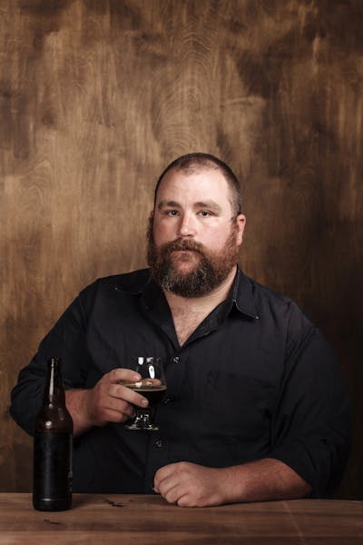 a man sitting at a table with wine glasses