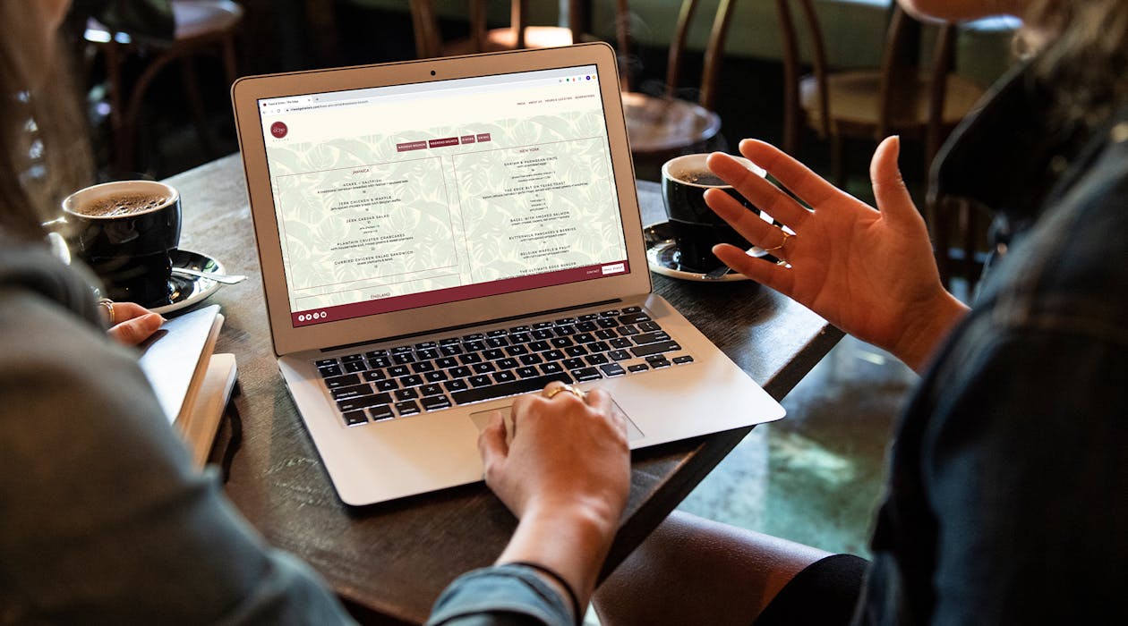 A customer and team member looking at a website on a laptop