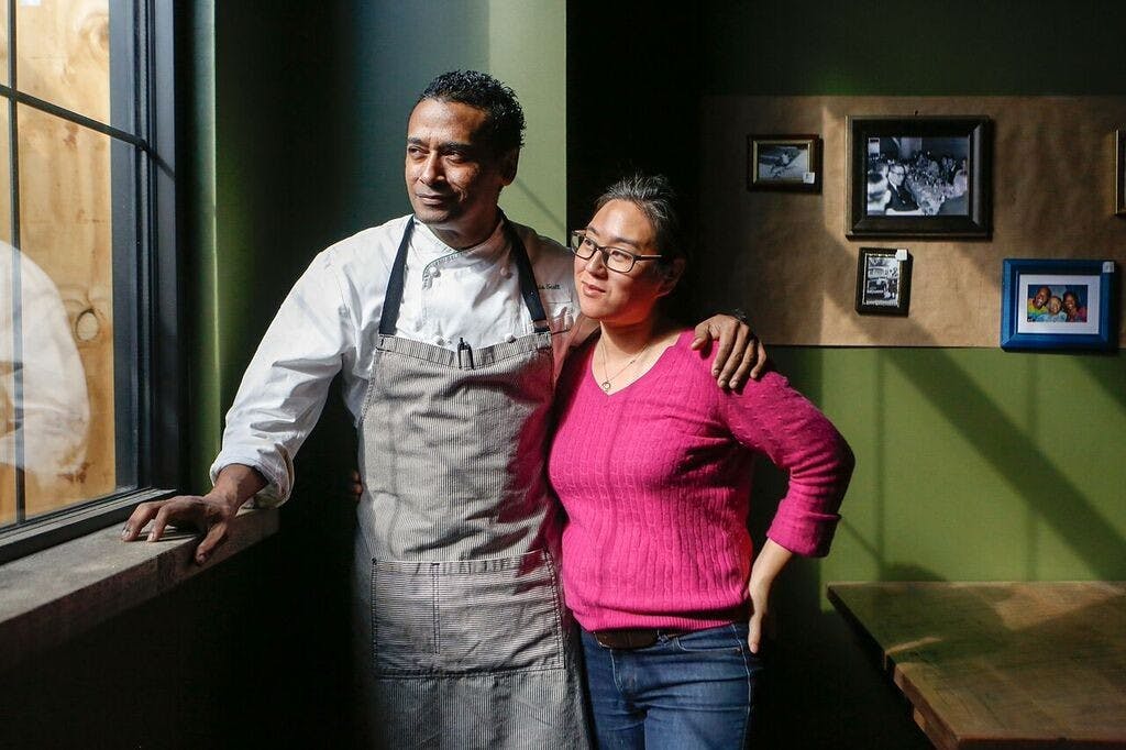 a man and a woman standing in front of a window