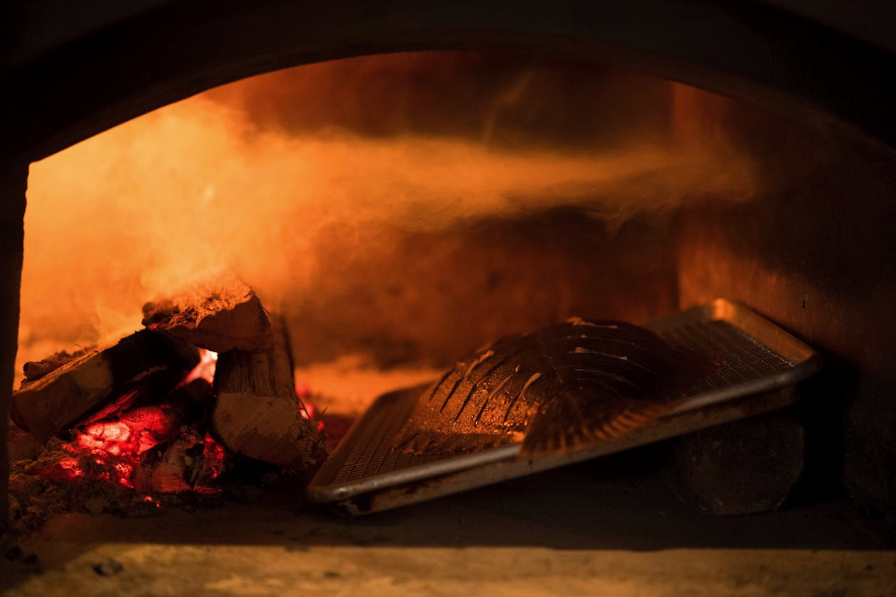 a pizza sitting on top of a fire oven