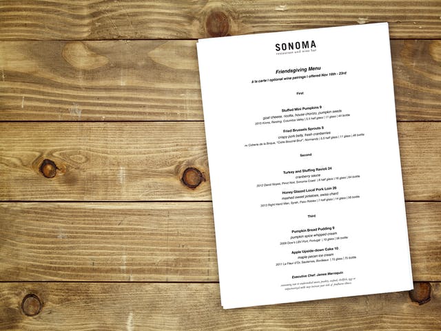 a wooden table with a restaurant menu on it. 