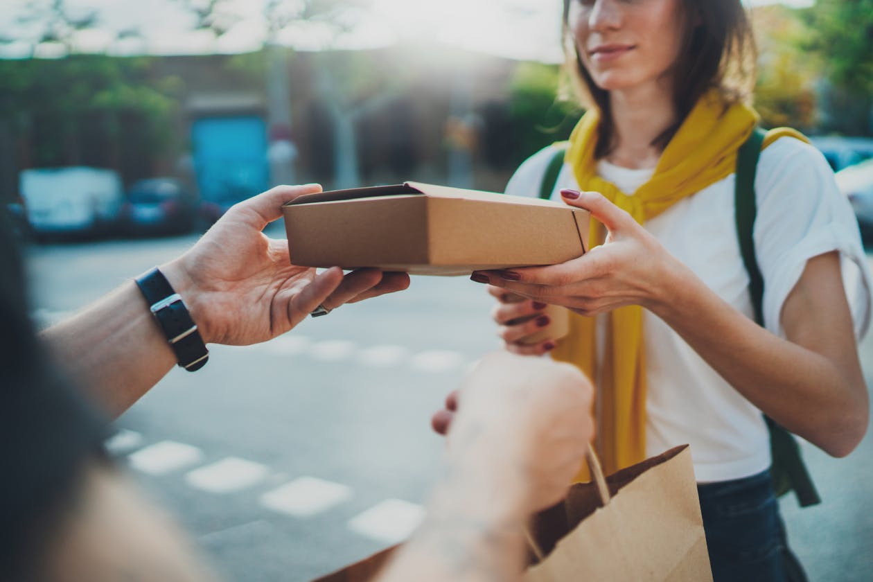 A woman being handed a restaurant to-go box