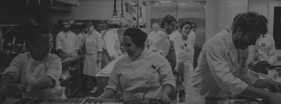 a group of people standing in a kitchen