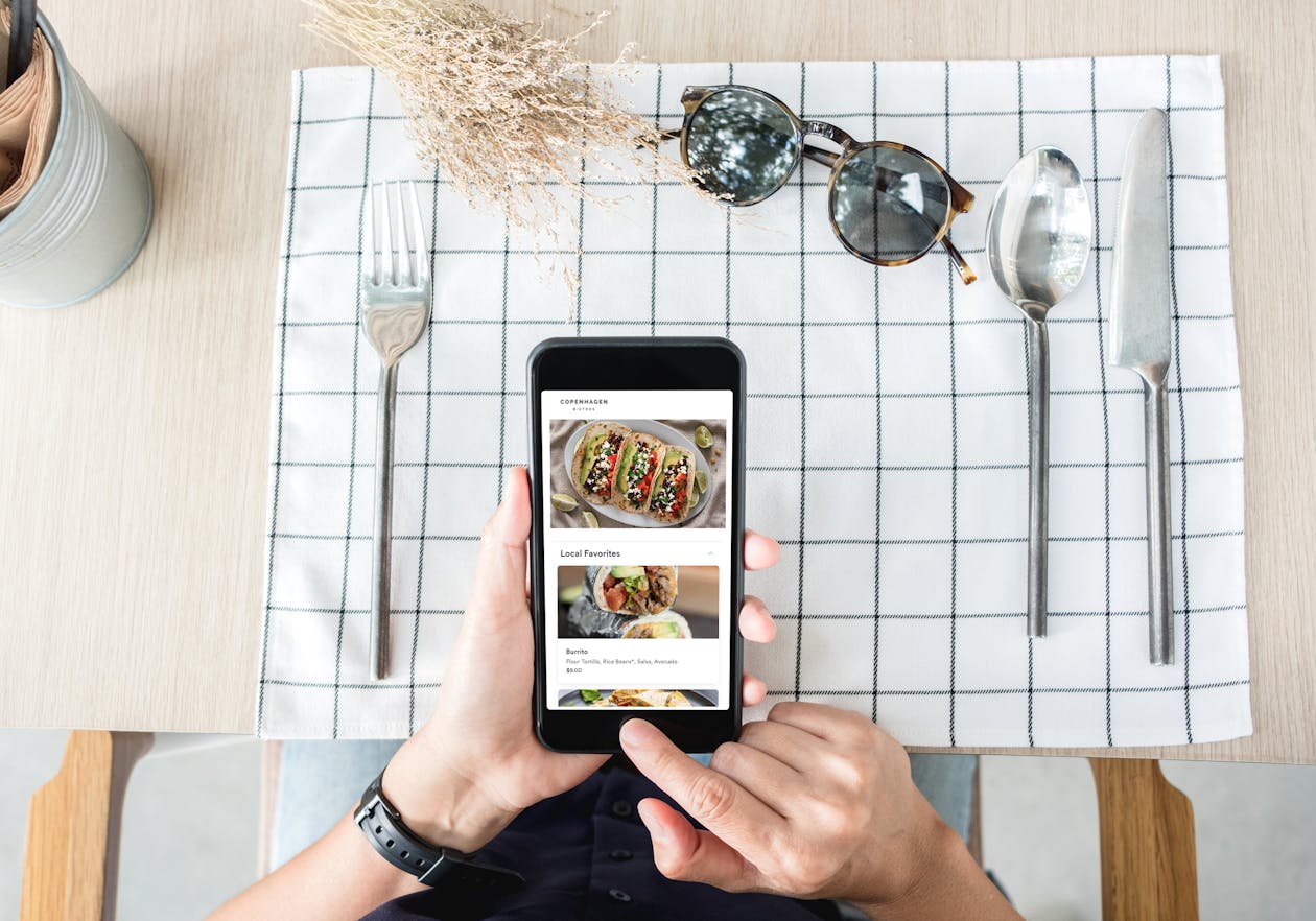Person sitting at a table with a mobile device