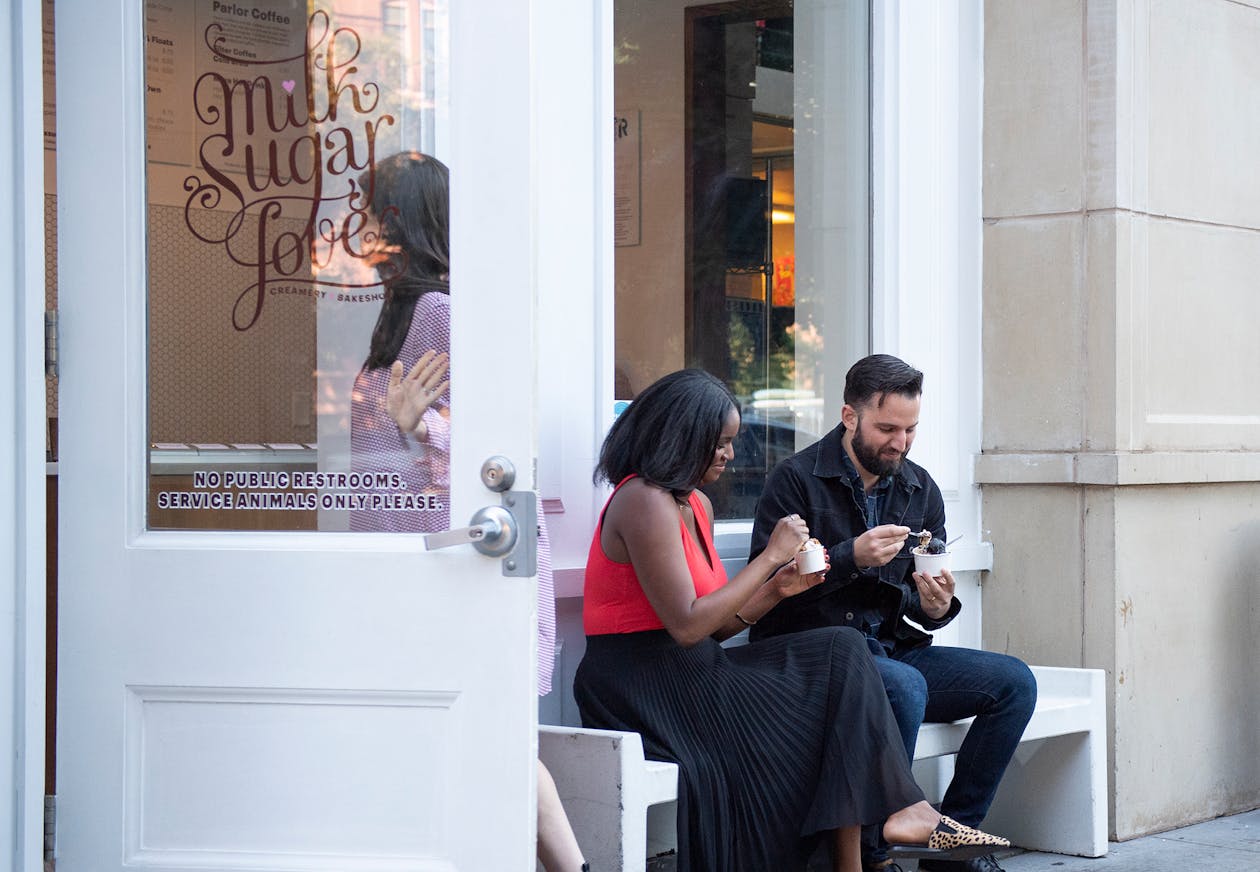 Two people eating ice cream on a bench