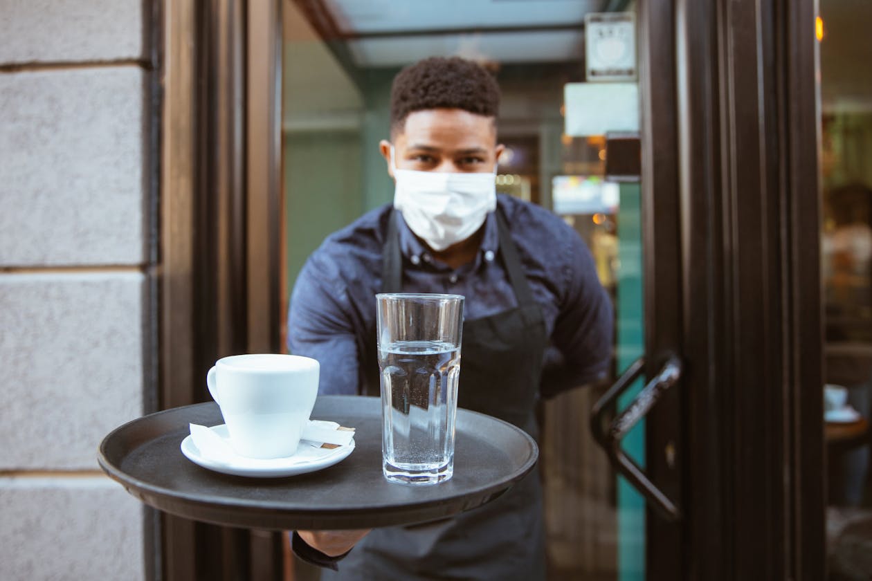 Restaurant staff with a coffee and glass of water on a tray