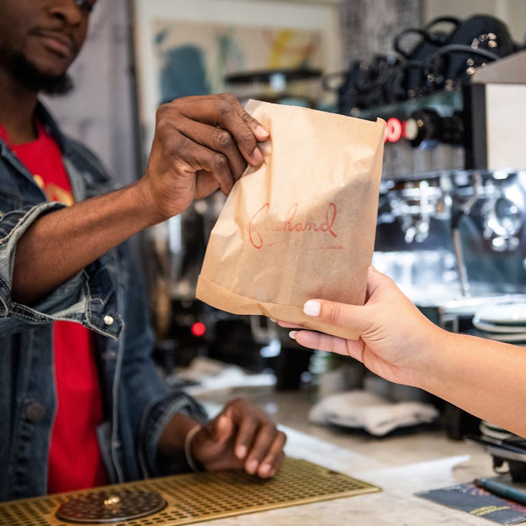 A server handing an item to a customer