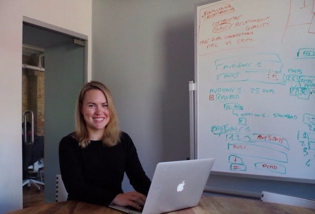 Mae Karwowski standing in front of a laptop computer