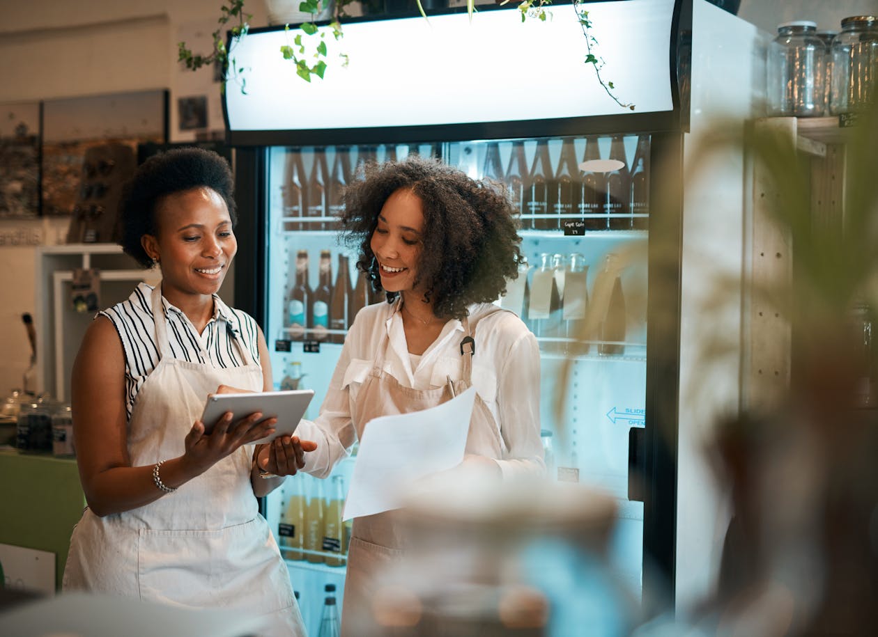 Two women looking at a tablet computer in a restaurant