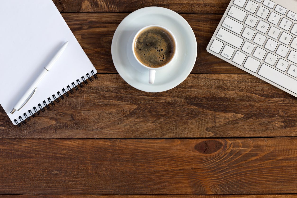 a cup of coffee sitting on top of a wooden table