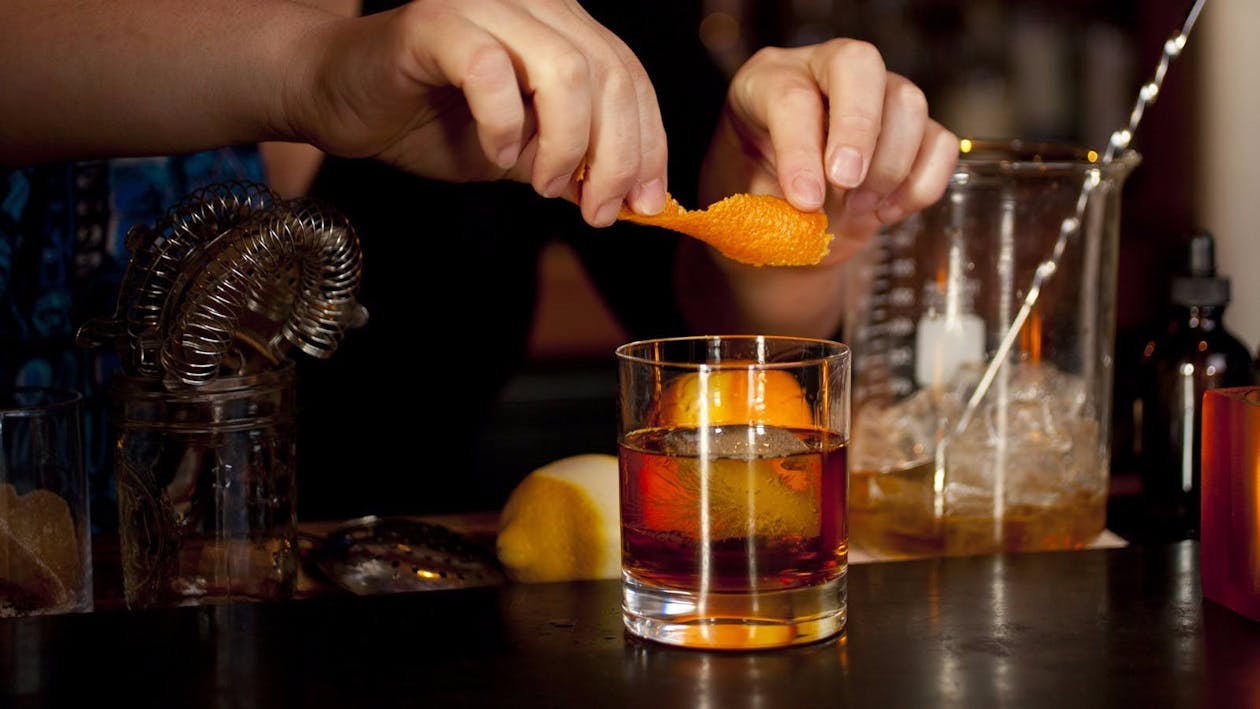 Orange peel being expressed over cocktial
