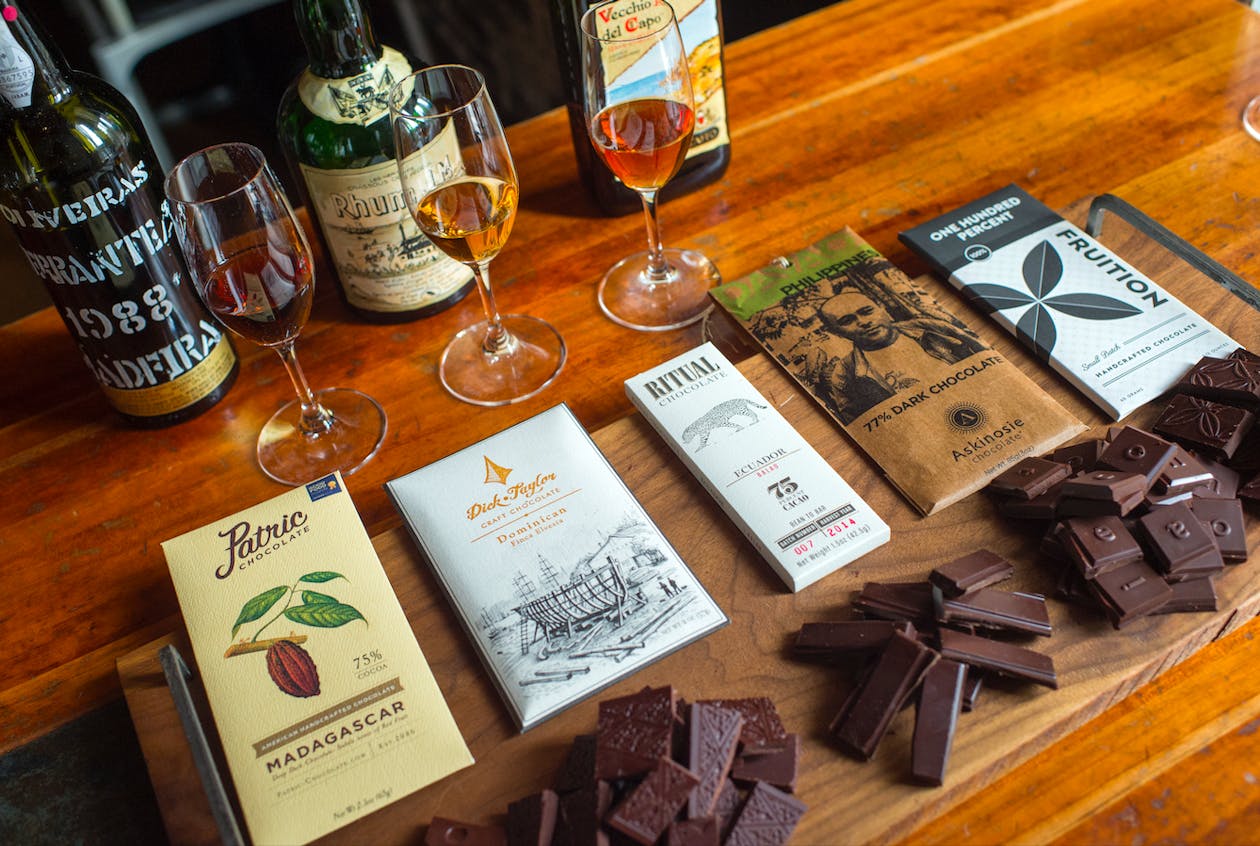 a bottle of wine and dark chocolate dessert board sitting on top of a wooden table at Hearth