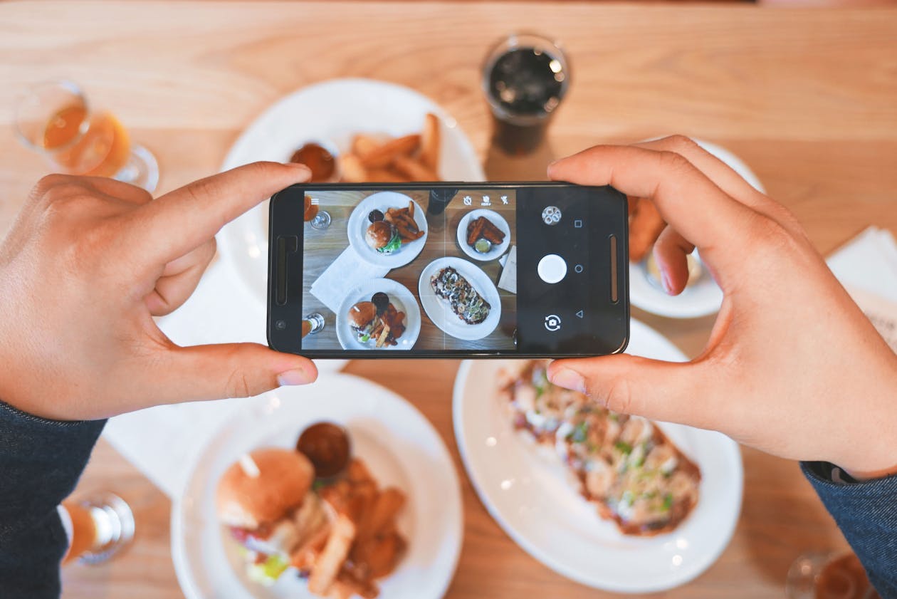 a person holding a plate of food on a table