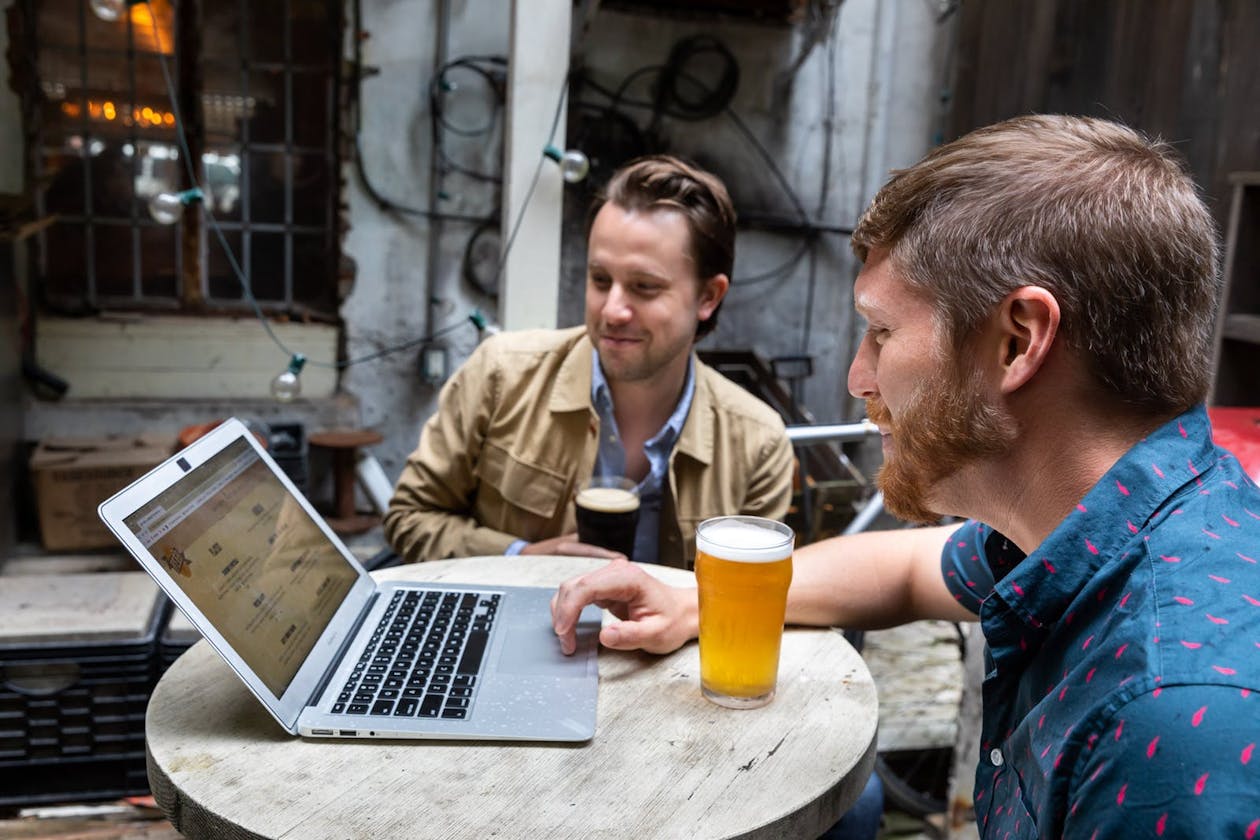 a man sitting at a table in front of a laptop