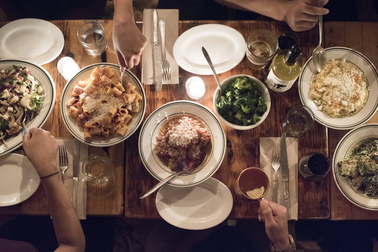 a group of people sitting at a table with a plate of food