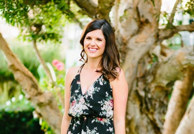 a woman standing in front of a tree