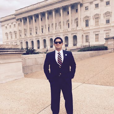 a man in a suit standing in front of a building