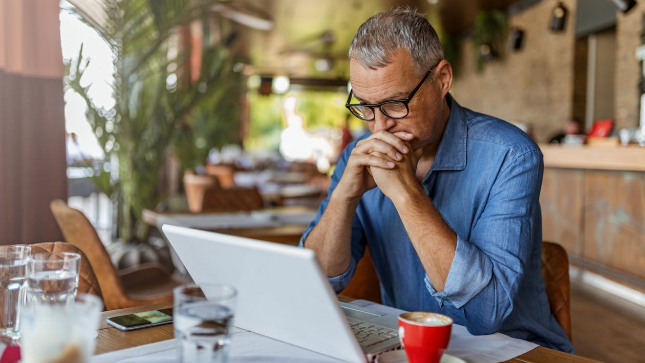 a man sitting at a table using a laptop