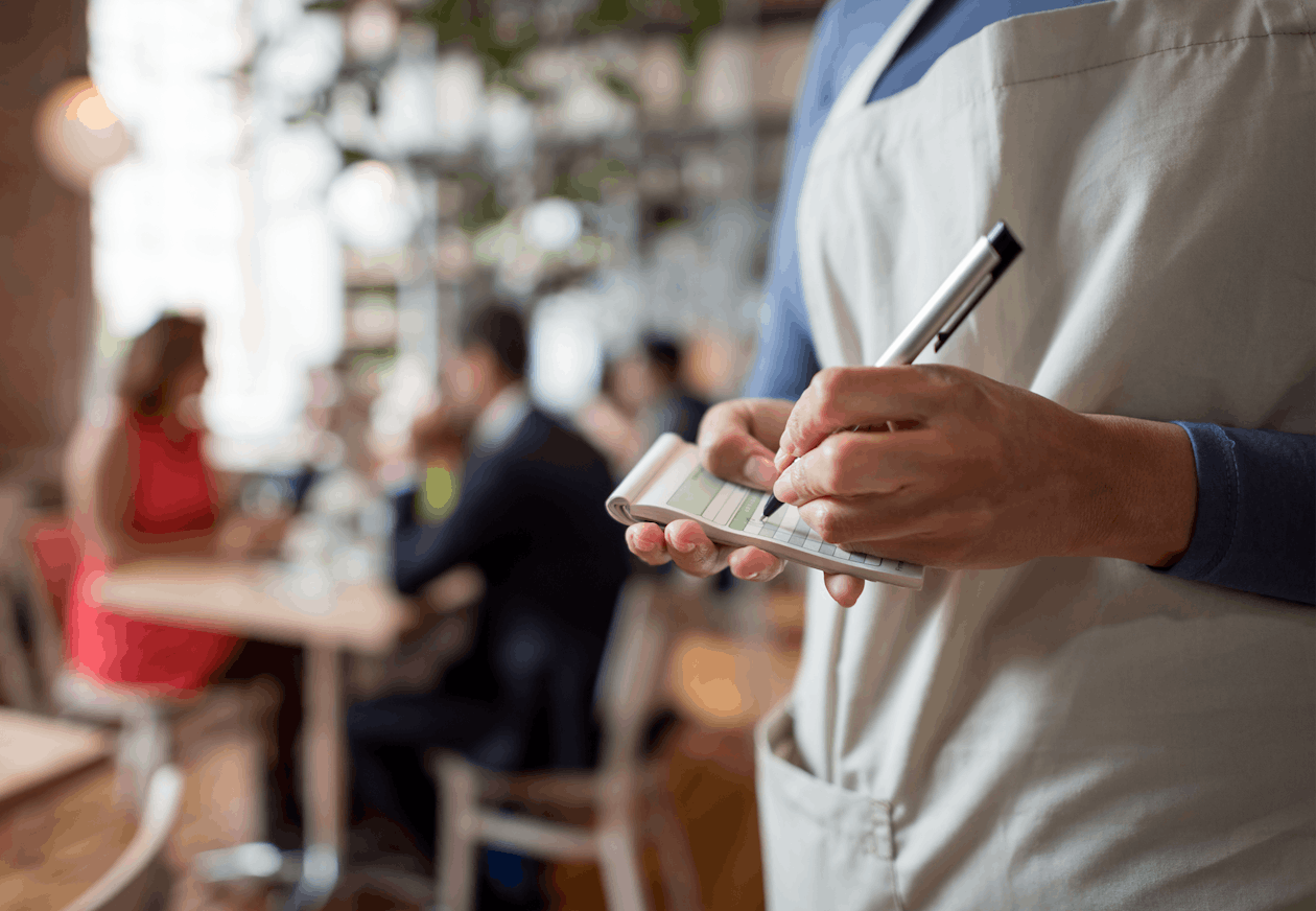 Close up shot of a waiter taking orders in a restaurant