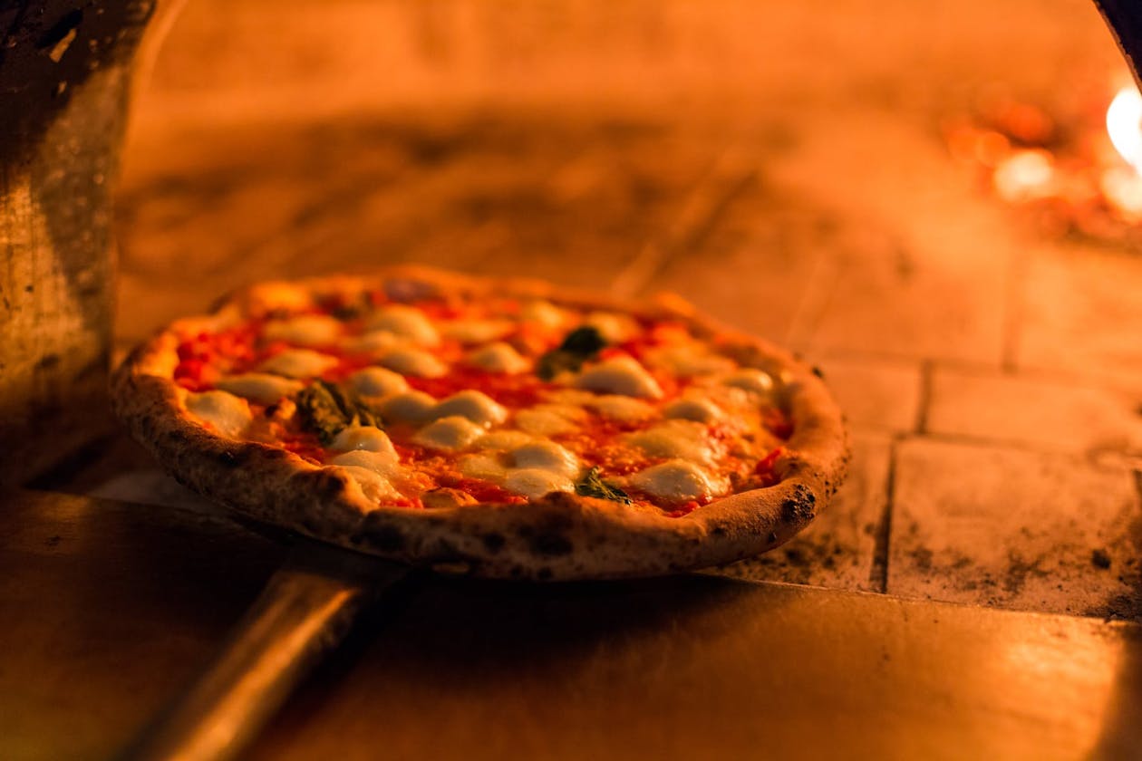 a pizza sitting on top of a wooden table